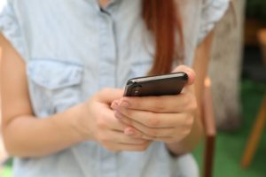 Woman replying to an automated text message - OnSpot Social App